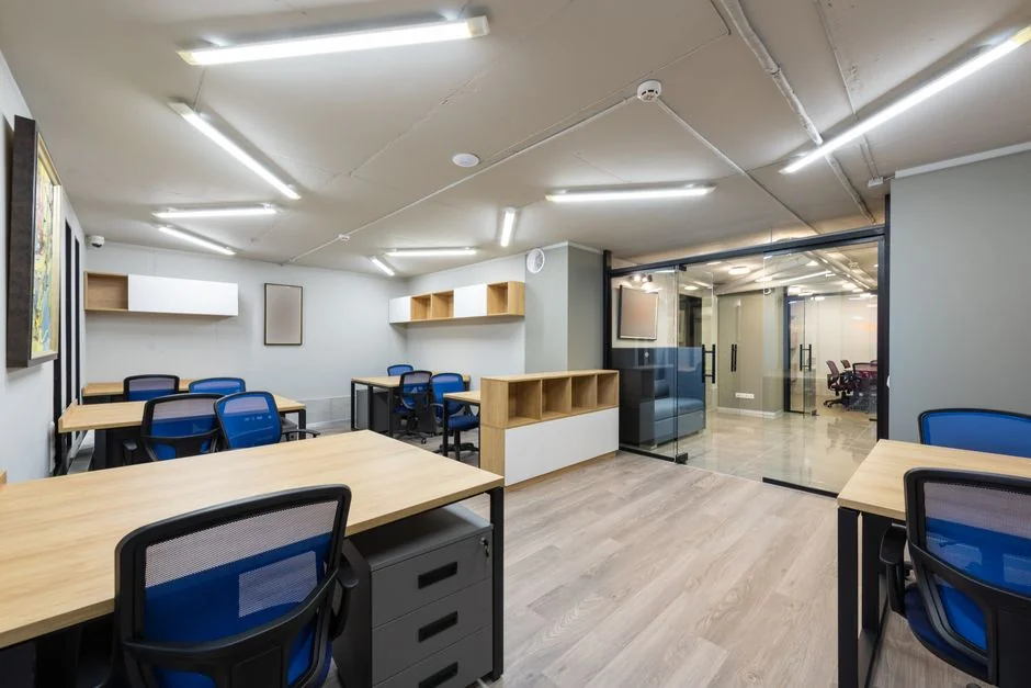 Un bureau net et bien rangé, avec de la papeterie et des produits de dépoussiérage pour un espace de travail efficace.